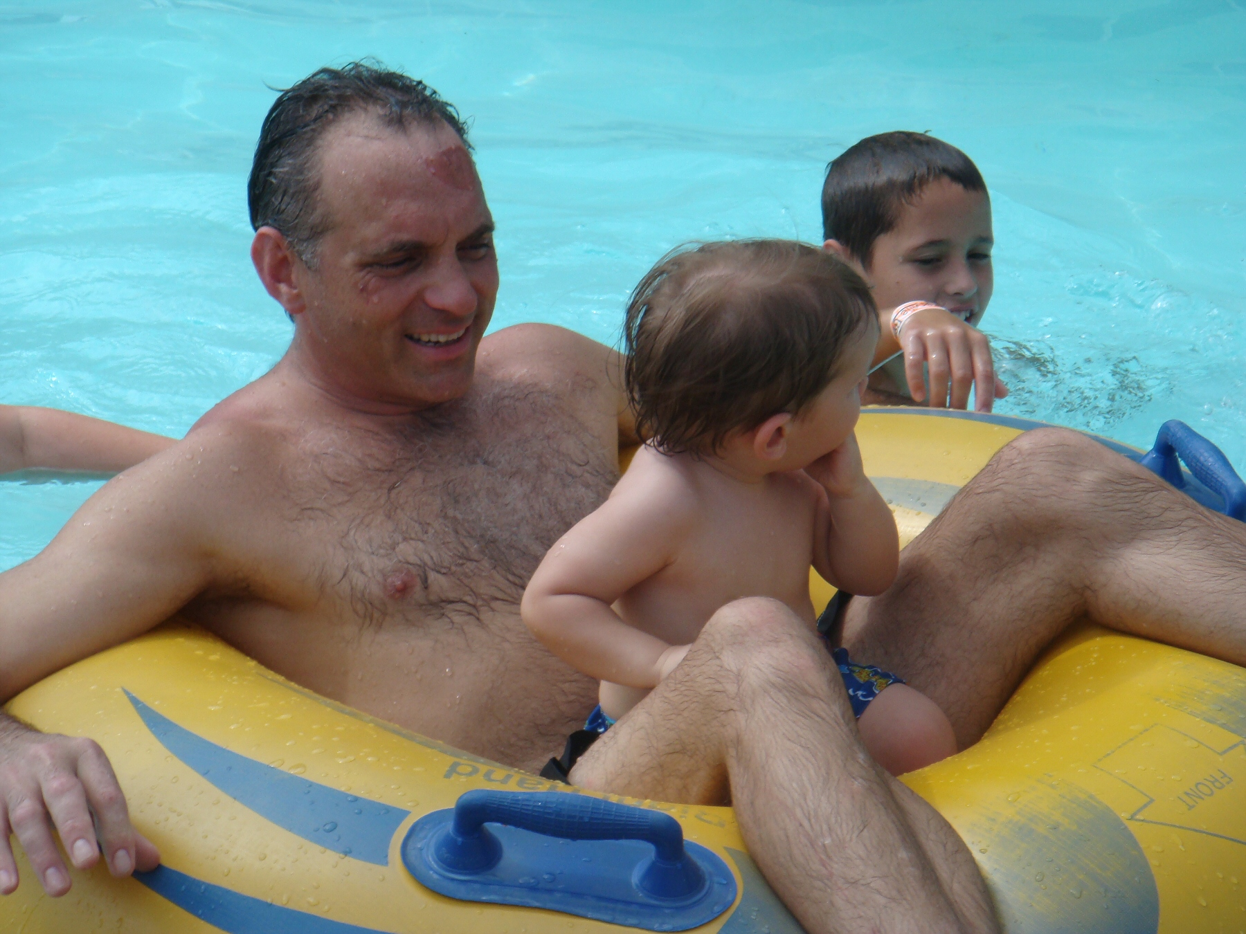 man and children in lazy river on float