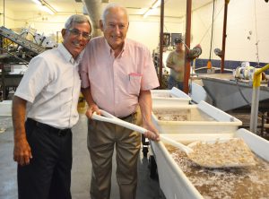 Founder Walton Kraver of Jubilee Seafood scooping shrimp with David Dekle