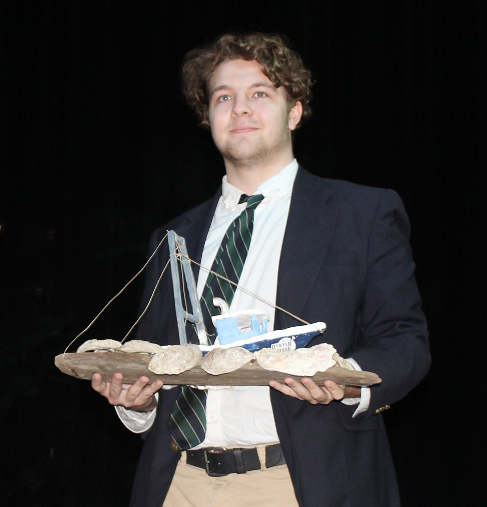 2018 Chelsea Garvin Spirit Scholarship winner Ford Taylor holding award-winning oyster boat