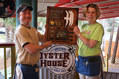 man and woman holding up island spirit award plaque