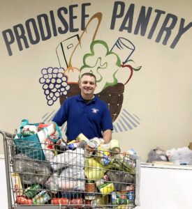 Employees at picnic drive, generously donated can goods to Prodisee Pantry. Pictured receiving the donation is Neil Beasley, program manager of Prodisee Pantry.