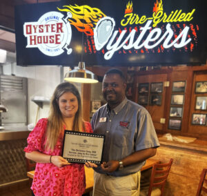 Pictured from left are Keli Shirazi, Mobile Film Office and Dre Lawson, Original Oyster House, receiving the EVA Award Plaque that will be installed in the restaurant. The award reads The EVA for most festive creative project 2022 for the Christmas Son, OOH version, sung by Dre Lawson. The prize also included a great swag bag from the Mobile Film Office.