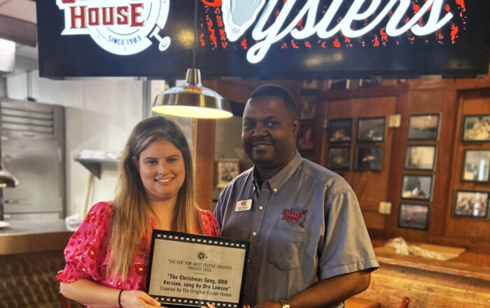 Pictured from left are Keli Shirazi, Mobile Film Office and Dre Lawson, Original Oyster House, receiving the EVA Award Plaque that will be installed in the restaurant. The award reads The EVA for most festive creative project 2022 for the Christmas Son, OOH version, sung by Dre Lawson. The prize also included a great swag bag from the Mobile Film Office.